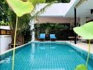 Modern outdoor pool area with surrounding greenery and lounge chairs