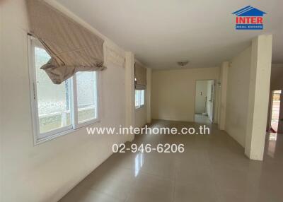 Spacious living room with tiled flooring and large windows