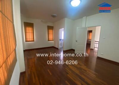 Main living area with wooden floors and large windows