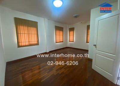 Empty bedroom with wooden flooring and large windows