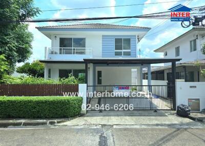 Front view of a modern two-story house with garage and garden