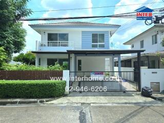 Front view of a modern two-story house with garage and garden