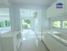 Bright modern kitchen with white cabinets and large windows