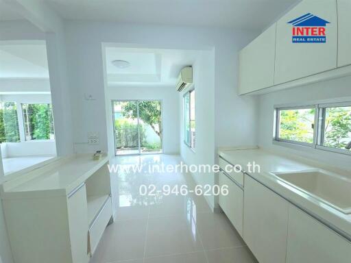 Bright modern kitchen with white cabinets and large windows