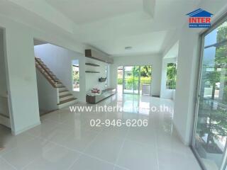 Spacious living room with modern design, large windows, and a view of the garden