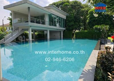 Swimming pool with adjacent modern building and lush greenery