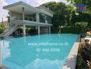 Swimming pool with adjacent modern building and lush greenery