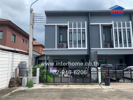 Modern townhome exterior with gates and driveway