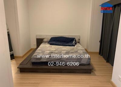 Double bed in a bedroom with wooden flooring and curtains