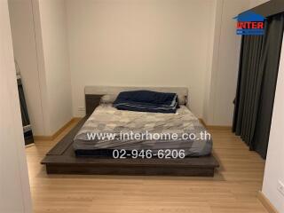 Double bed in a bedroom with wooden flooring and curtains