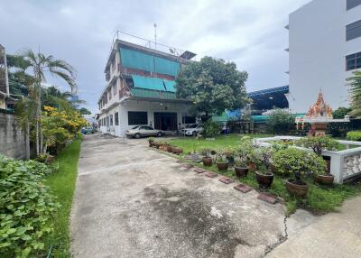 A two-story building with a driveway and garden