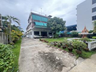 A two-story building with a driveway and garden