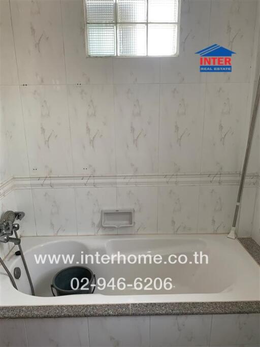 Bathroom with tiled walls, bathtub, and shower