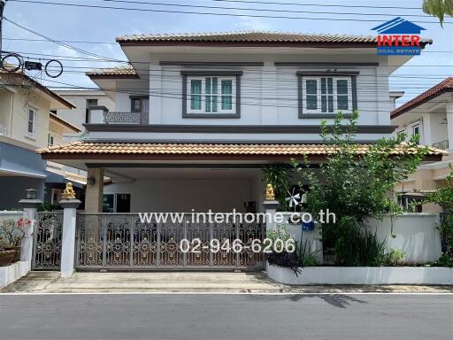 Front view of a two-story house with a gated driveway