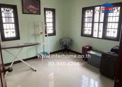 Bright bedroom with ironing board and luggage