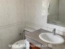 Bathroom with sink, toilet, and tiled walls