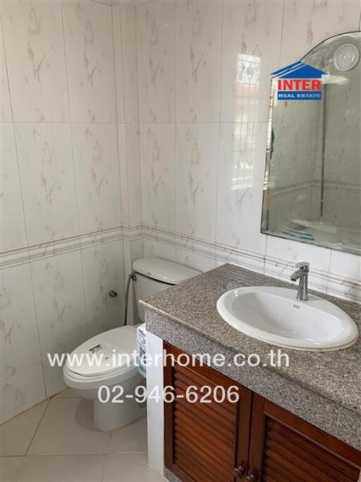 Bathroom with sink, toilet, and tiled walls