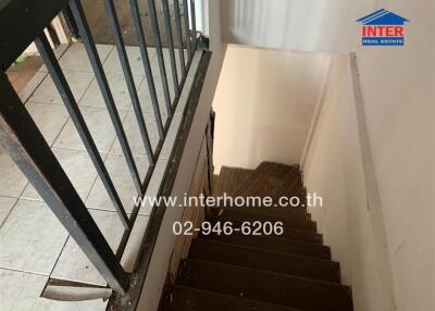 Staircase with tiled floor and railing leading to a lower floor.