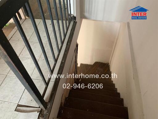 Staircase with tiled floor and railing leading to a lower floor.