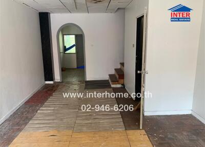 Interior view showing hallway with mixed flooring and arched doorway