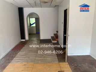 Interior view showing hallway with mixed flooring and arched doorway