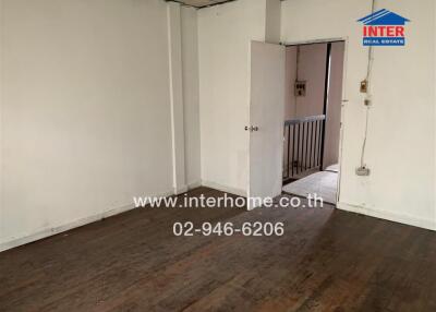 Interior view of a room with wooden flooring and open door