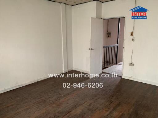 Interior view of a room with wooden flooring and open door