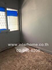 Empty bedroom with barred window and damaged floor