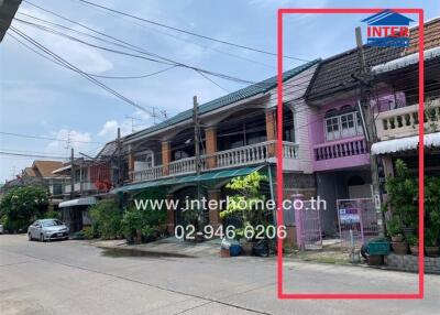 A row of residential townhouses with balconies and various exteriors