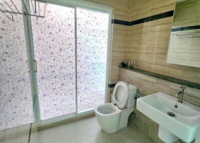 Modern bathroom with sliding glass door and floral frosted glass