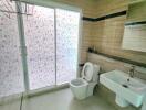 Modern bathroom with sliding glass door and floral frosted glass