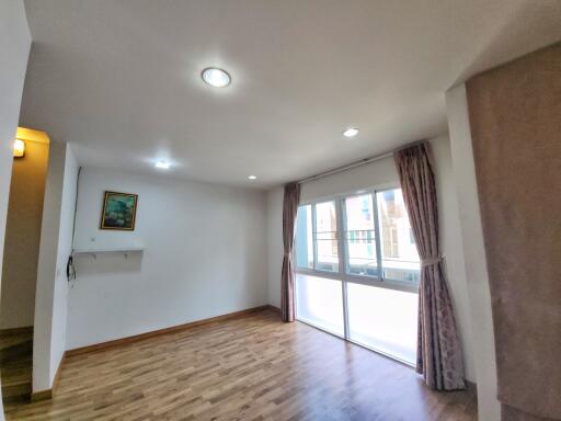 Bright living room with wooden flooring and large windows