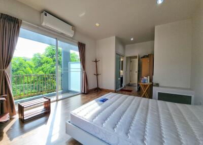 bright bedroom with large windows and balcony access