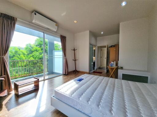 bright bedroom with large windows and balcony access