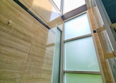 Modern bathroom with wooden tiles and high windows