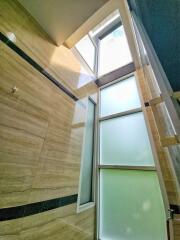 Modern bathroom with wooden tiles and high windows