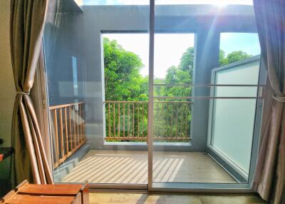 Bright balcony with glass door and lush green view