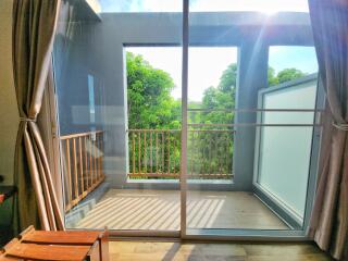 Bright balcony with glass door and lush green view