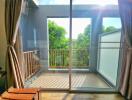 Bright balcony with glass door and lush green view