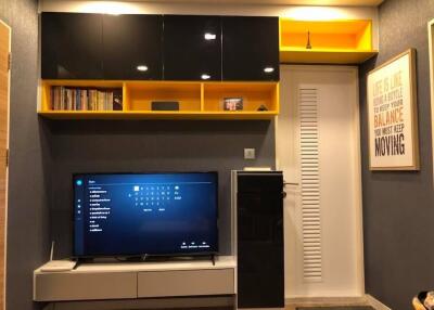 Modern living room with a television, shelving units, and contemporary decor