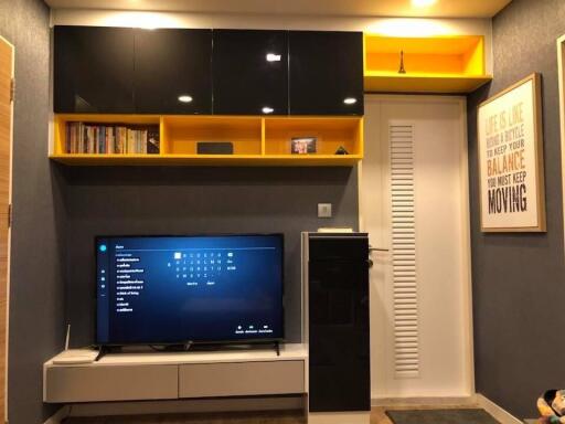 Modern living room with a television, shelving units, and contemporary decor