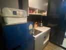 Compact modern kitchen with blue refrigerator