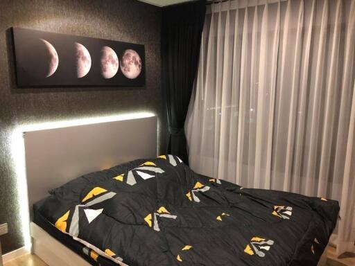 Modern bedroom with large bed, moon phase artwork and floor-to-ceiling window with curtains