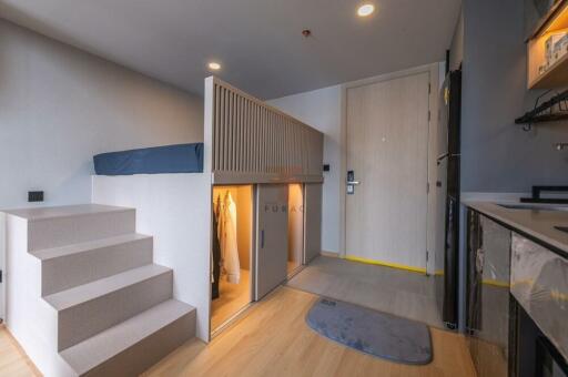 Modern studio apartment with elevated bed and built-in storage