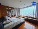 Spacious bedroom with a large window overlooking cityscape, wooden floors, and built-in wardrobe.