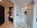 Modern bathroom with a glass shower, sink, and storage area