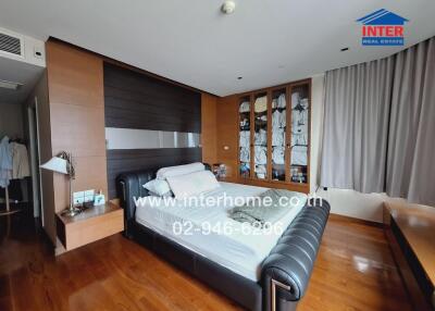 Modern bedroom with wooden flooring, a large bed, and built-in wardrobes