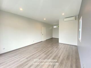 Spacious living room with wooden flooring and natural light