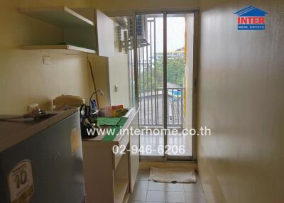 Compact kitchen with refrigerator and access to balcony