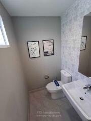 Modern bathroom with sink, toilet, and wall décor